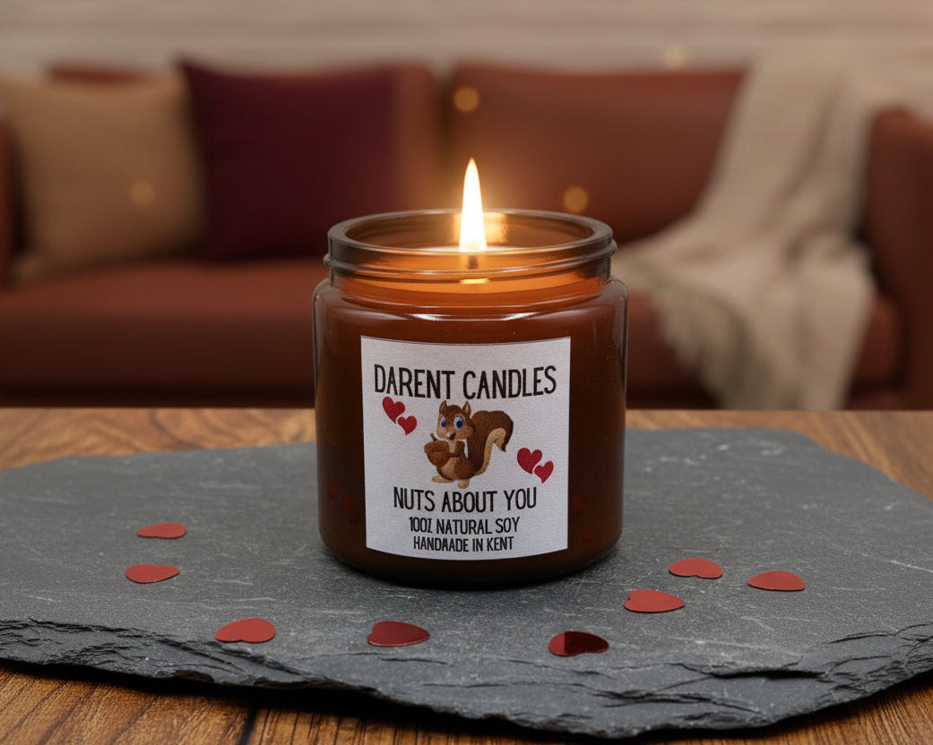 Candle in an amber jar with a 'Darent Candles' label on a slate surface.