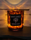 Candle in a tortoiseshell-patterned holder with 'Darent Candles' label on a wooden surface.
